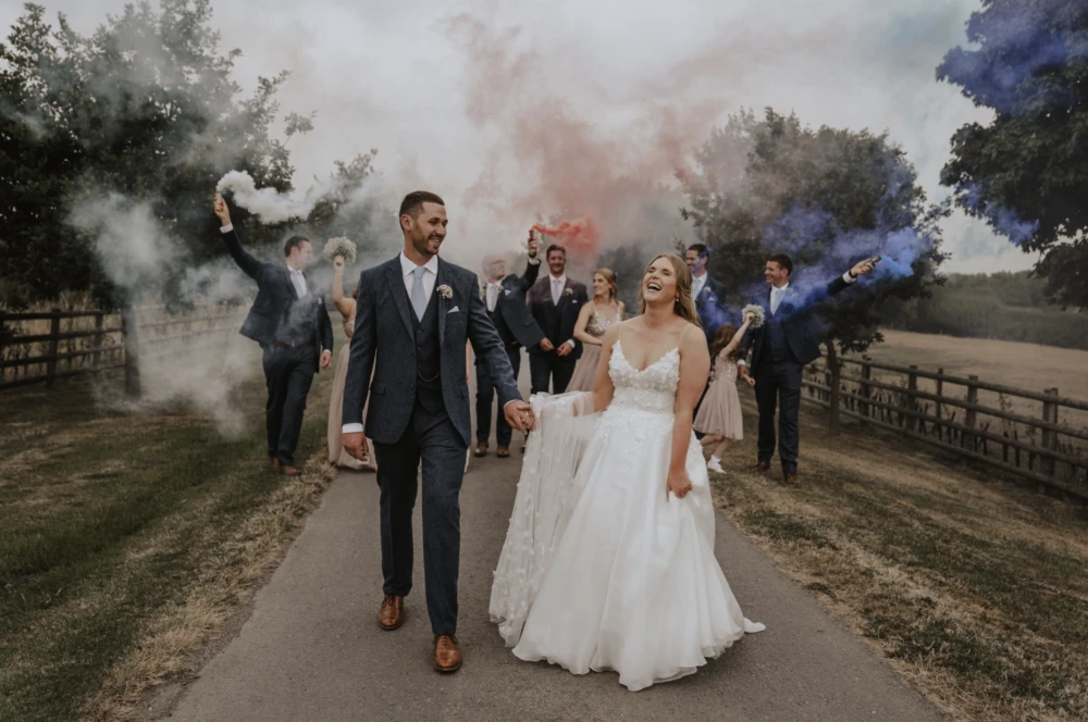 Bride groom and their guests with smoke canisters