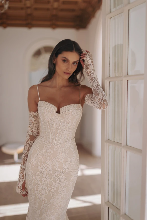 Model in fitted wedding dress with sleeves