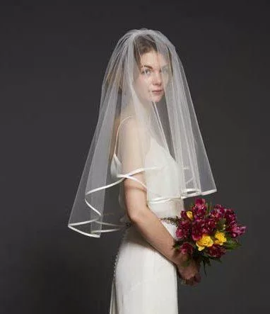 Model wearing an elbow length veil with a satin ribbon edge.