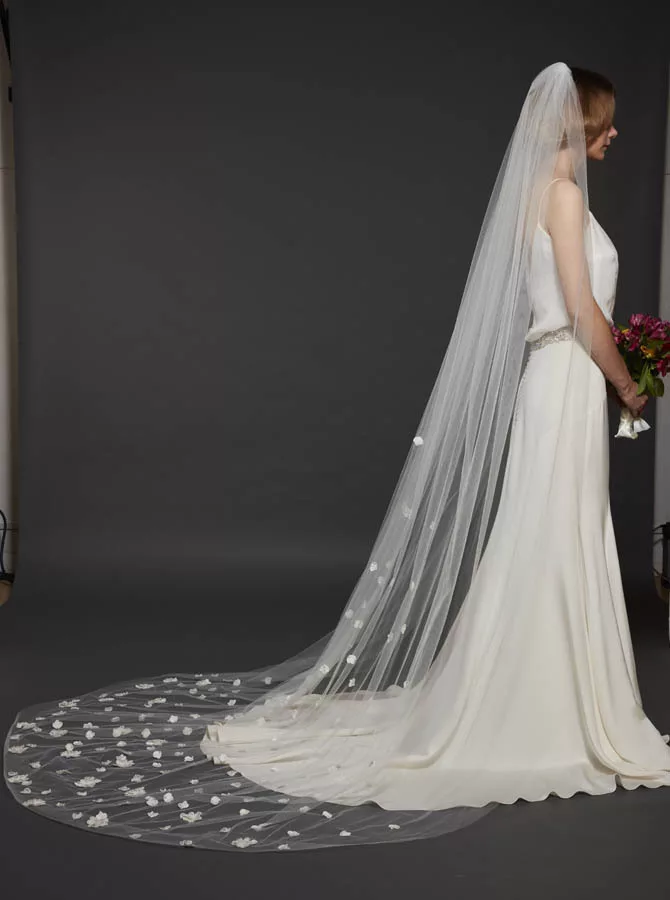 Model wearing a chapel length veil with floral petal detailing at the bottom.