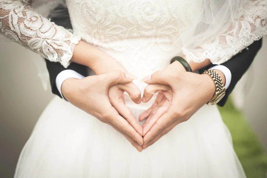 Man and women making a heart with their hands